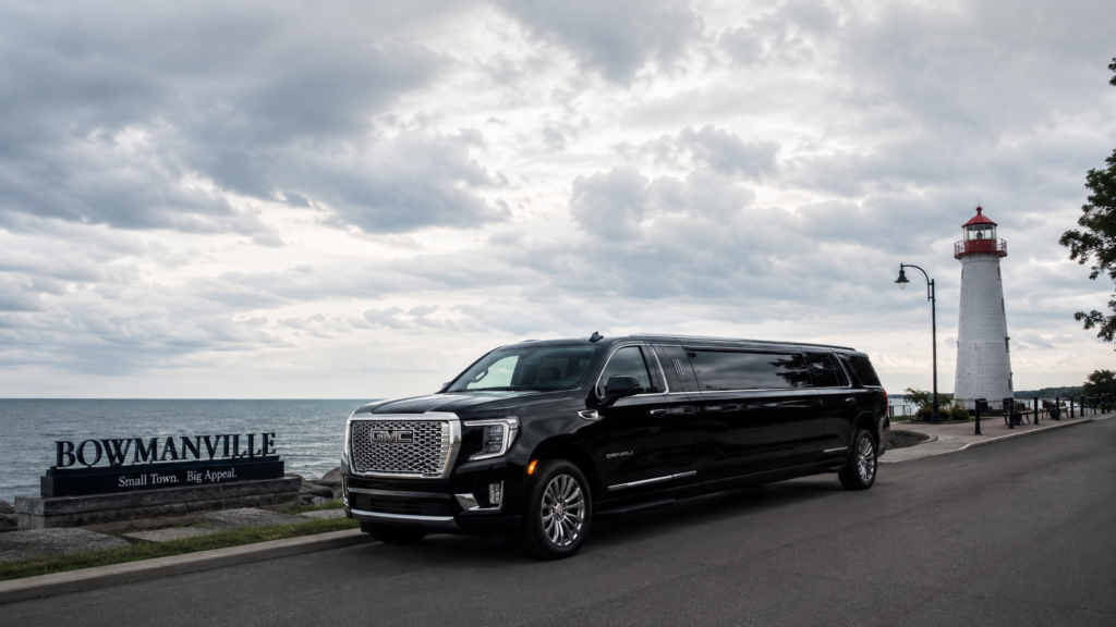 White luxury SUV limo parked along a scenic coastal road in Bowmanville.