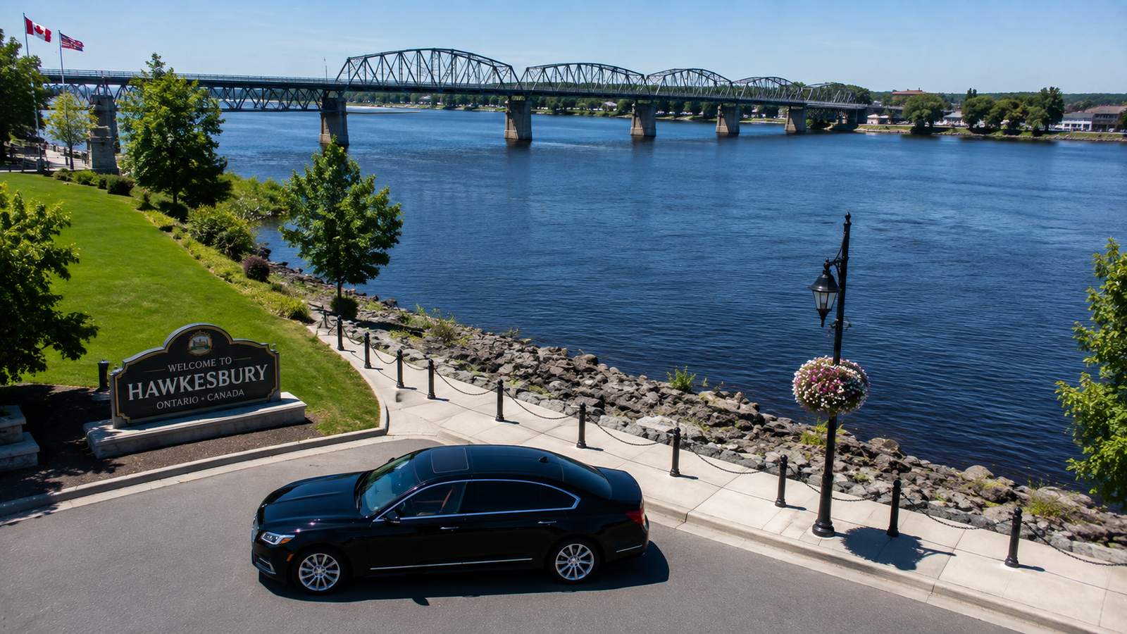 White luxury sedan limo parked near an Ottawa River bridge in Hawkesbury.
